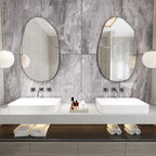 Set of two irregular oval wall mirrors with black frames, ideal for modern bathroom vanity decor.
