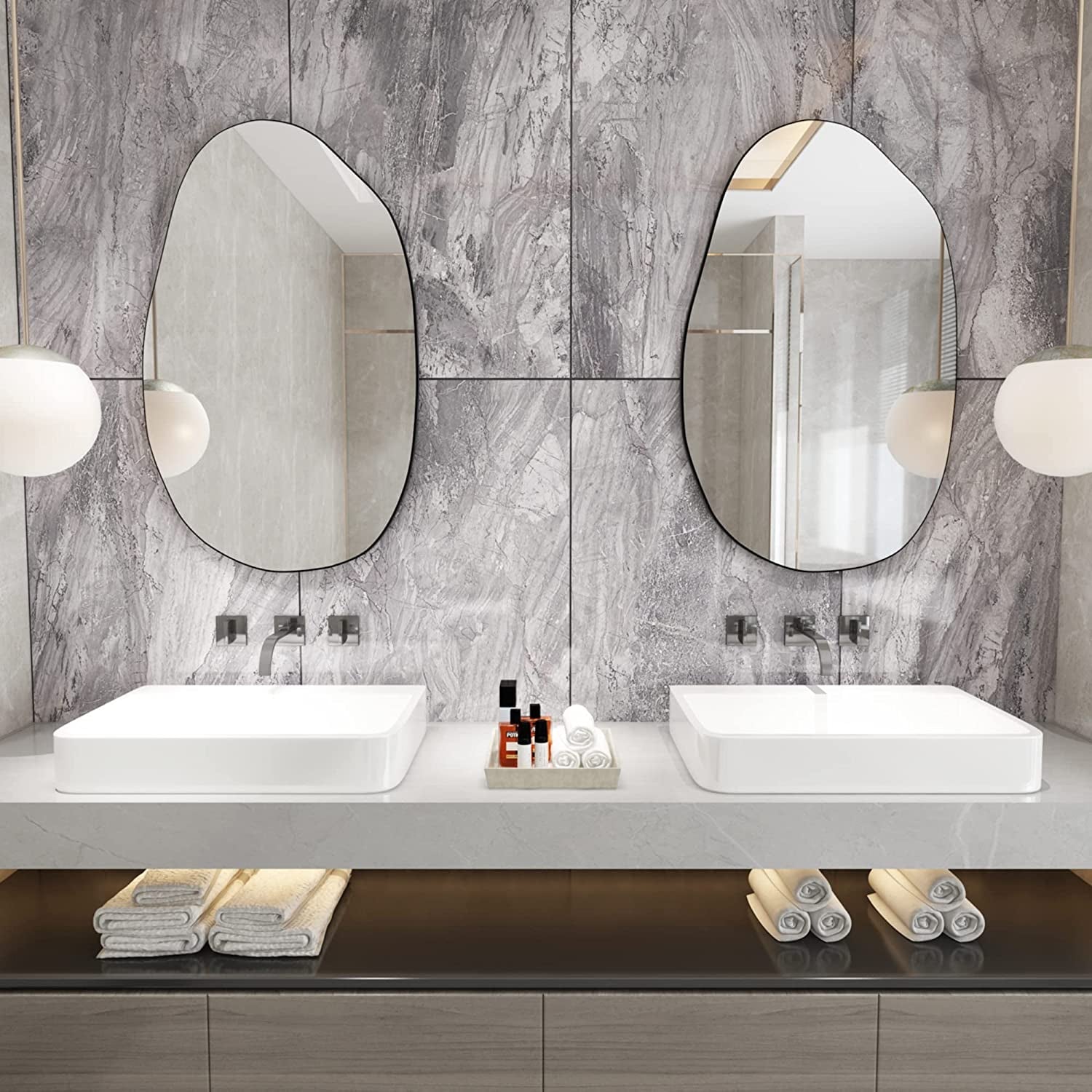 Set of two irregular oval wall mirrors with black frames, ideal for modern bathroom vanity decor.
