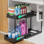 Two-tier black sliding storage organizer placed under a sink, holding bottles of laundry detergent and cleaning supplies