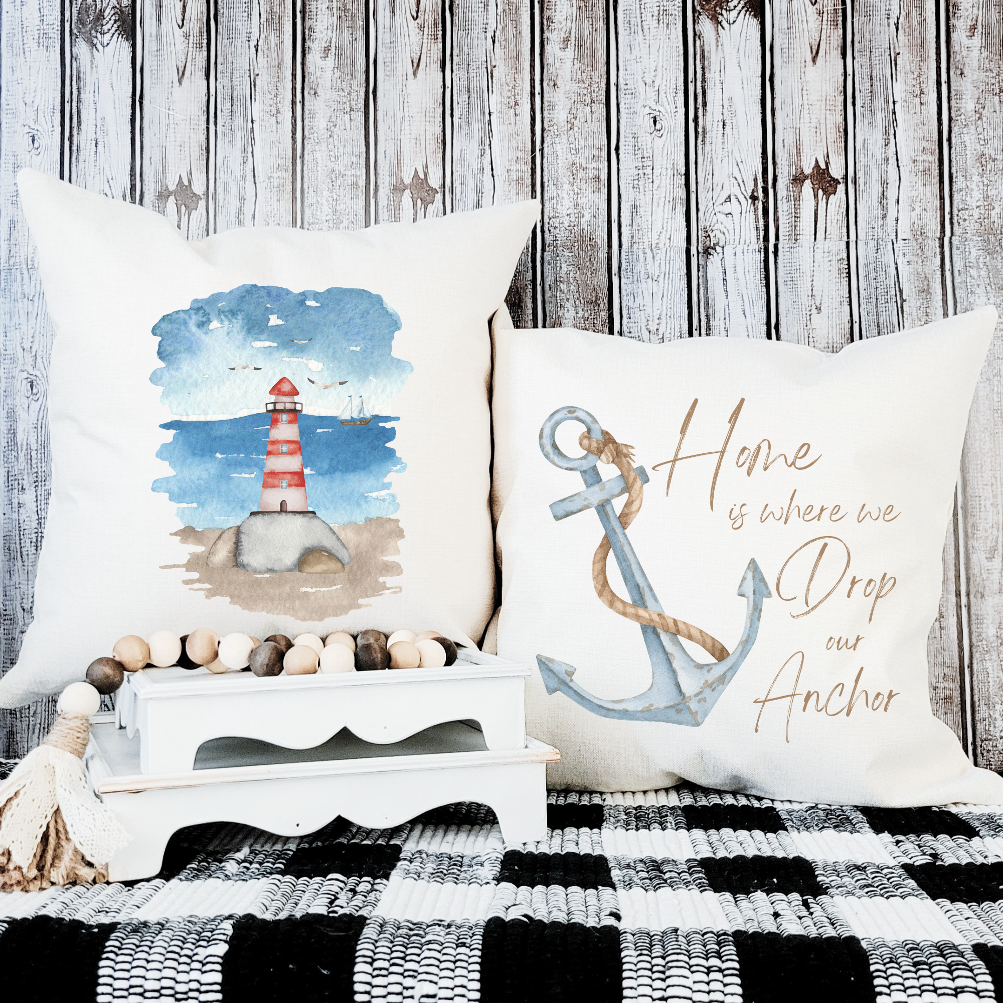 Coastal pillow set with lighthouse and anchor designs for nautical beach house decor.
