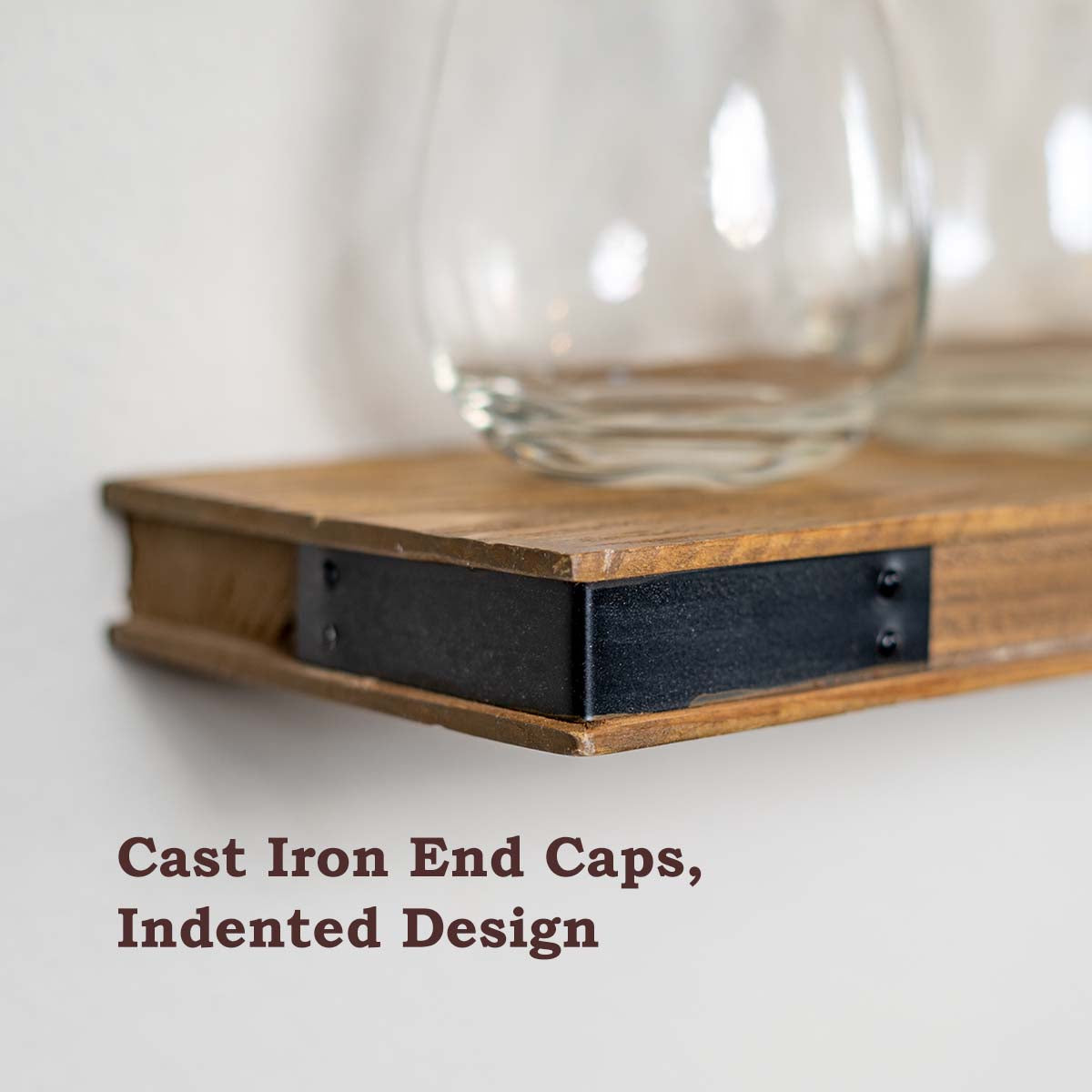 Rustic wood floating shelf with cast iron end caps and indented design.
