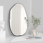 Irregular oval wall mirror with black frame for modern bedroom, bathroom, or hallway decor.
