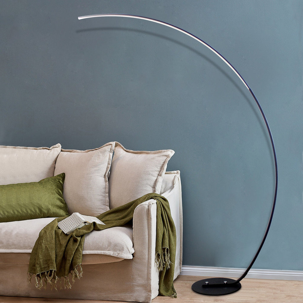 Modern curved floor lamp with sleek arc design beside sofa