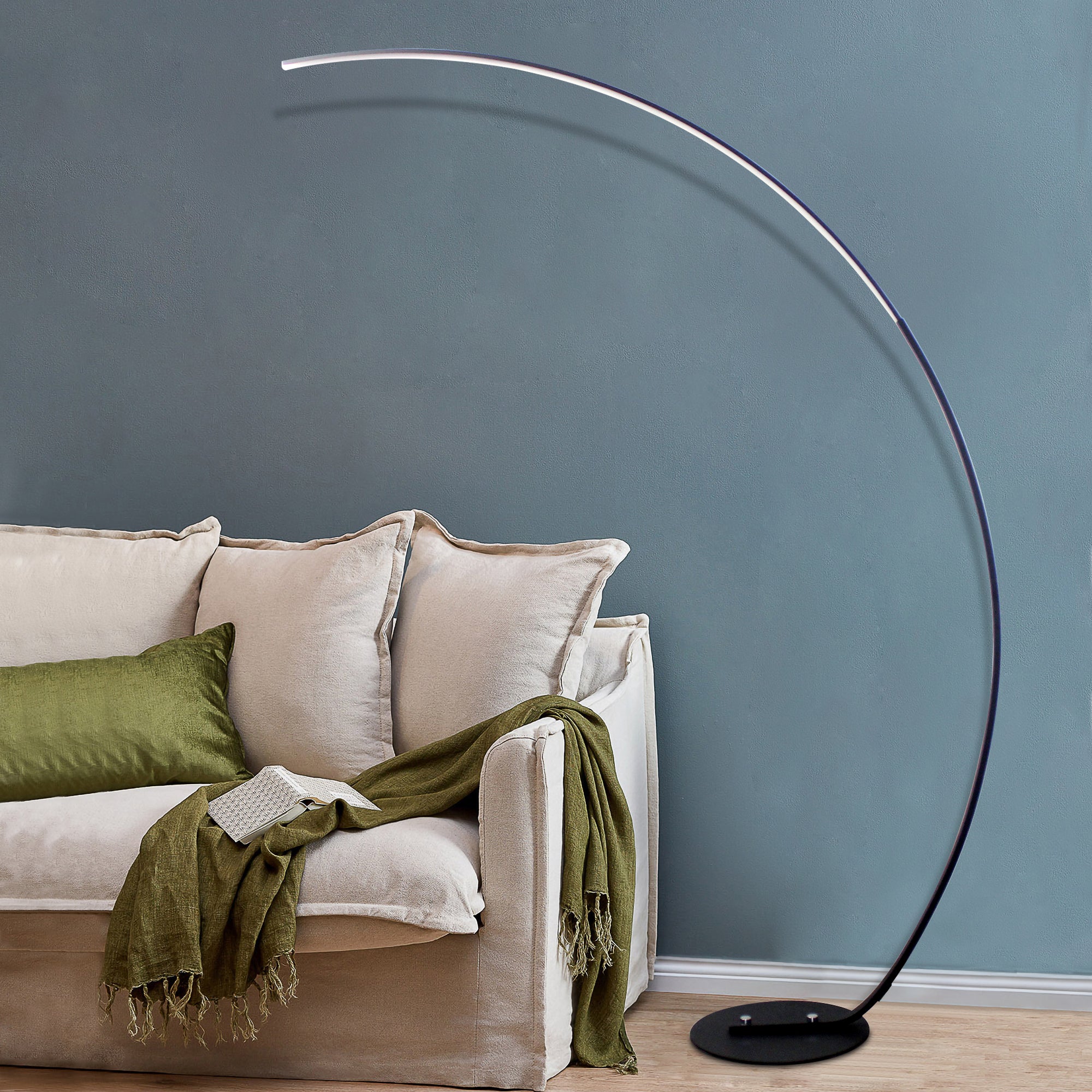 Modern curved floor lamp with sleek arc design beside sofa