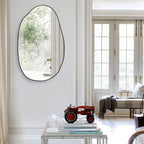 Irregular oval wall mirror with black frame, perfect for living room, hallway, or entryway decor.
