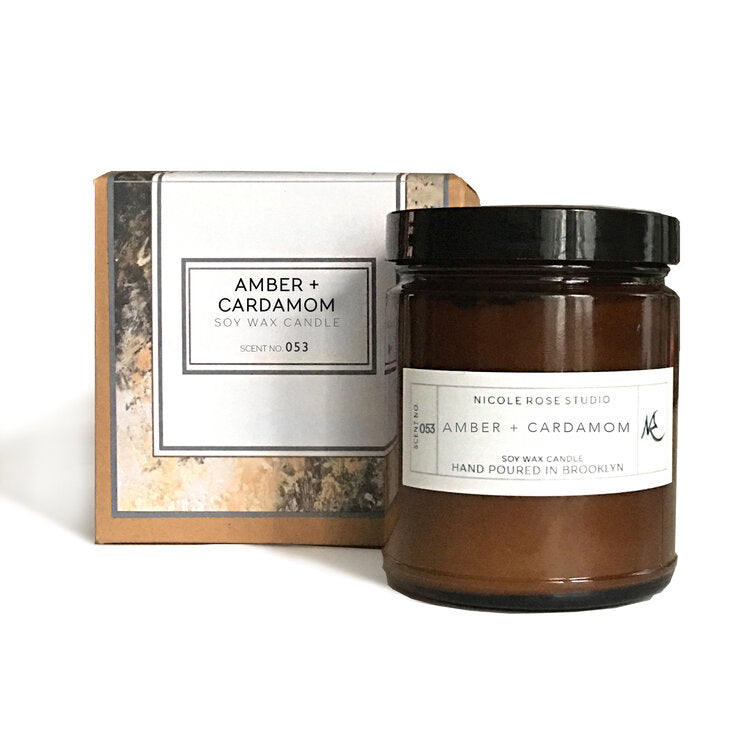 Amber and cardamom soy candle in amber jar, warm natural home fragrance.
