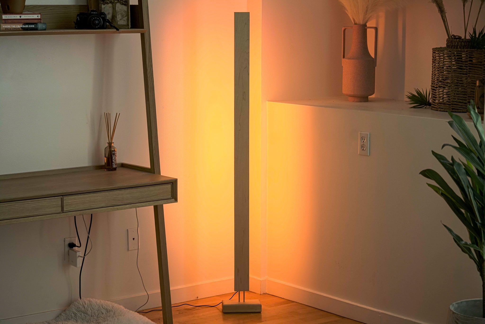 Minimalist LED corner floor lamp with warm ambient lighting for modern decor.
