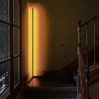 LED corner floor lamp with warm amber glow by staircase