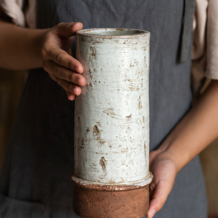 Handmade rustic tall ceramic vase with distressed finish for farmhouse home decor.
