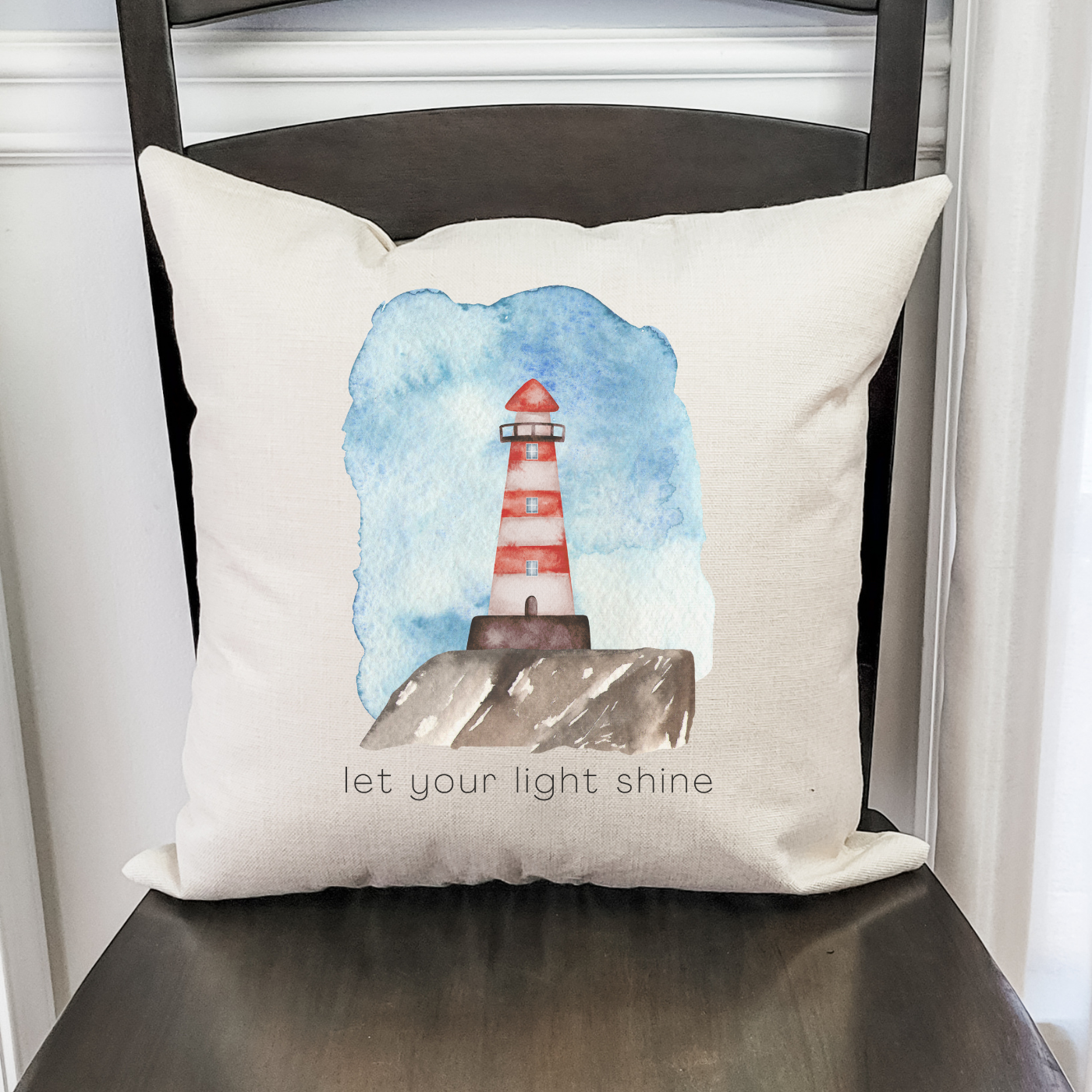 Coastal pillow cover with red lighthouse design and quote for nautical home decor.
