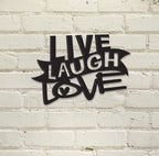 Black "Live Laugh Love" wall decor on white brick background