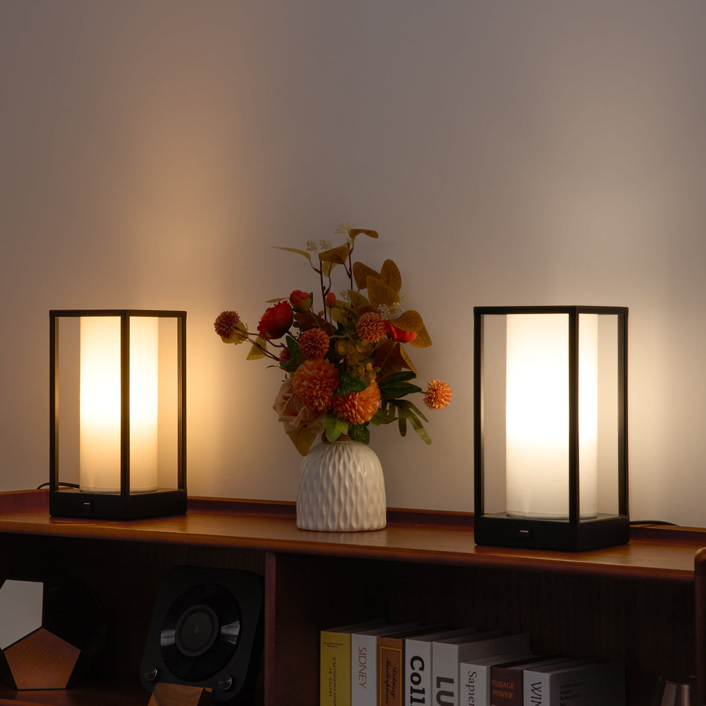 Pair of rectangular table lamps with warm light on shelf