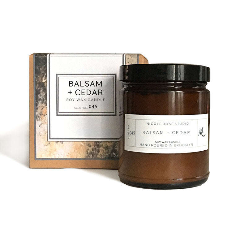 Balsam and cedar soy candle in amber jar, earthy and woodsy fragrance.
