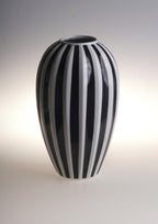 Elegant black and white striped ceramic vase with modern minimalist design.
