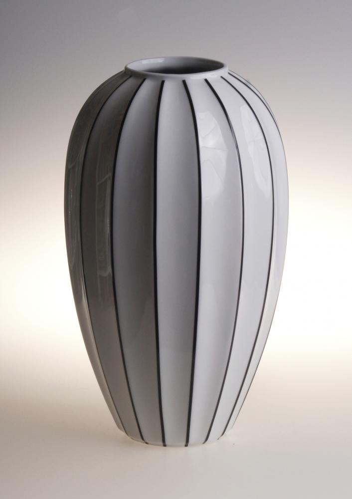 Modern black and white ceramic vase with sleek striped design for contemporary home decor.
