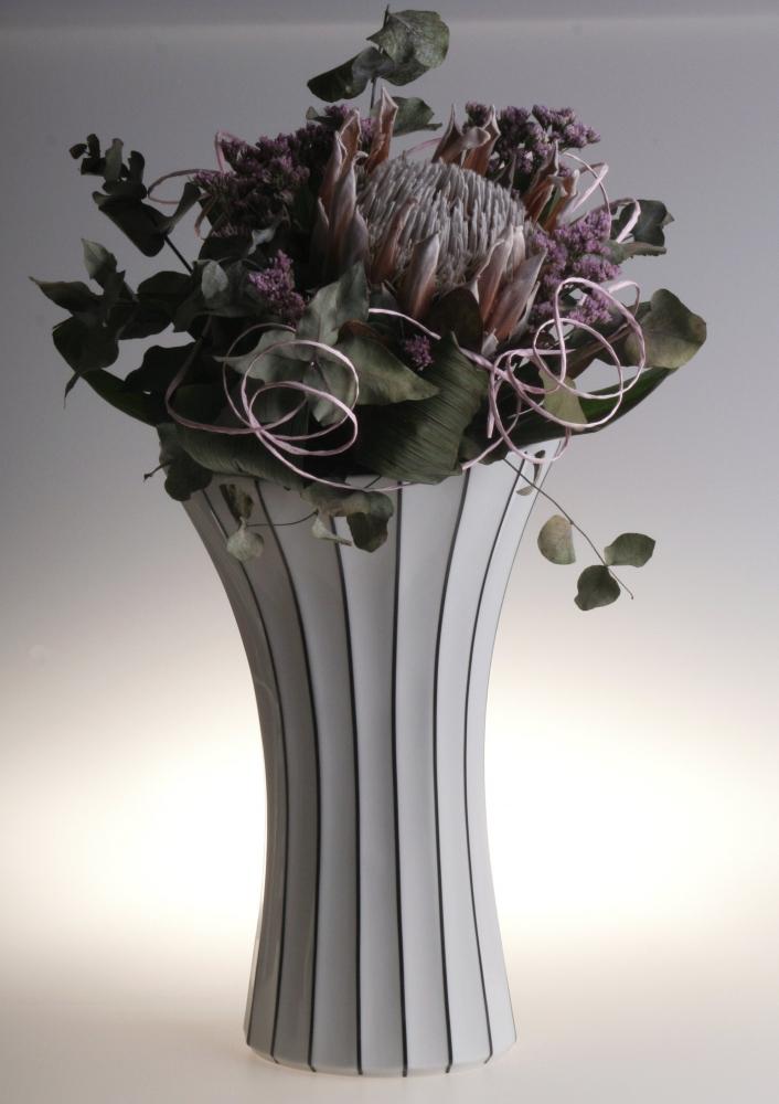 Modern black and white striped vase with floral arrangement for contemporary home decor.
