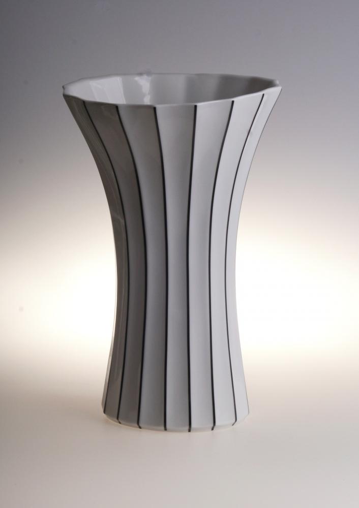 Stylish black and white striped ceramic vase with flared modern design.
