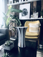 Sleek silver and black striped ceramic vase with flared design for modern home decor.
