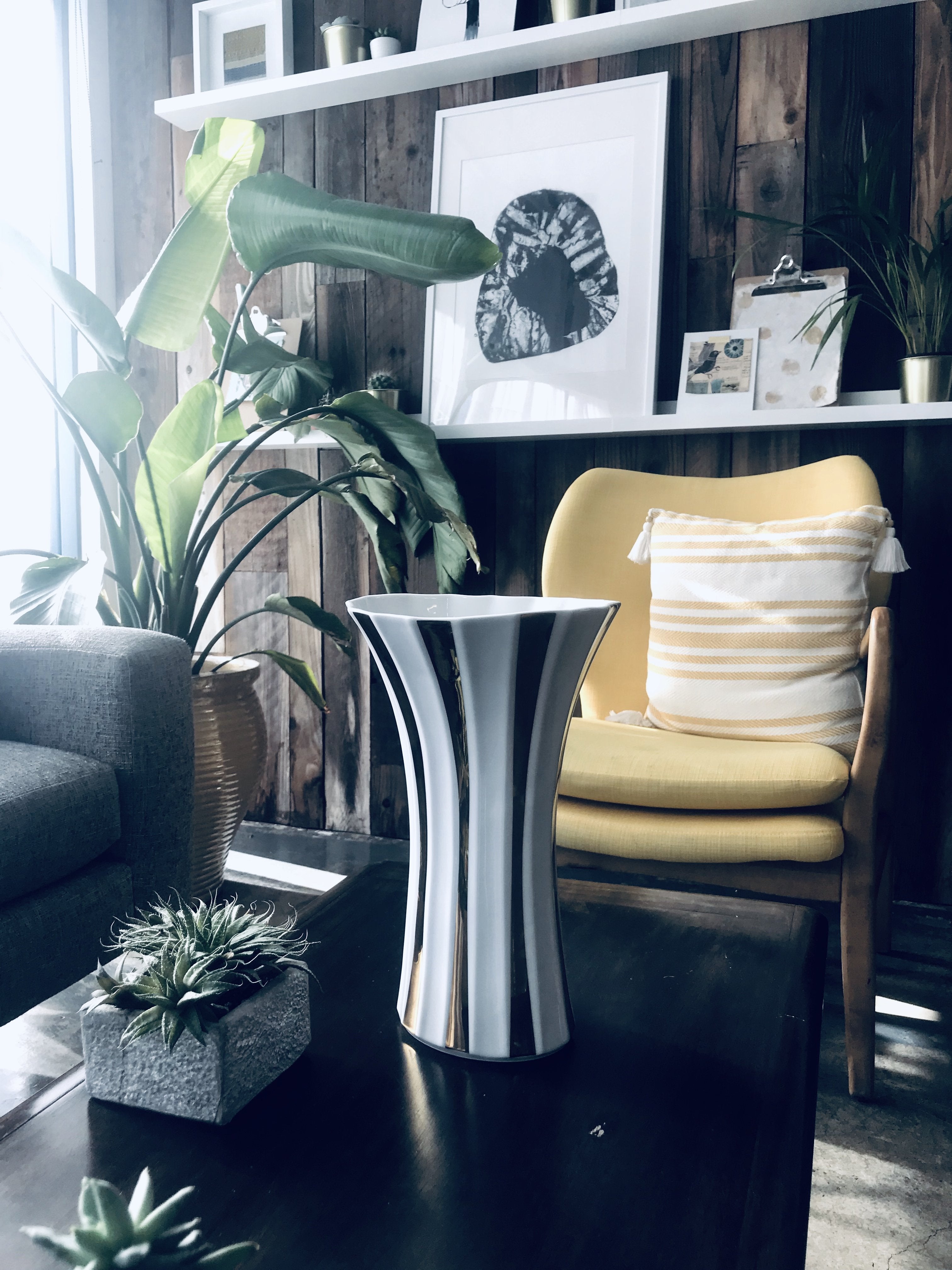 Sleek silver and black striped ceramic vase with flared design for modern home decor.
