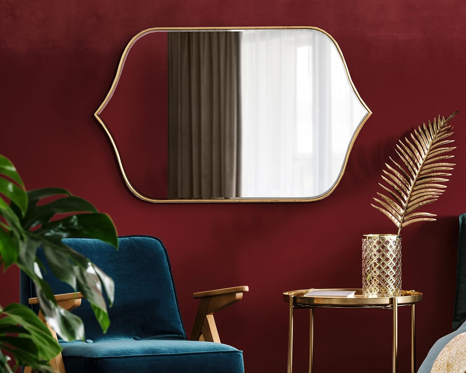 Decorative gold-framed wall mirror with unique curved design for living room or entryway.
