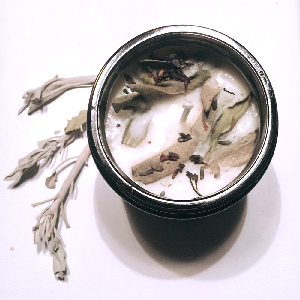 Herbal soy candle with dried lavender and sage leaves for natural aromatherapy.
