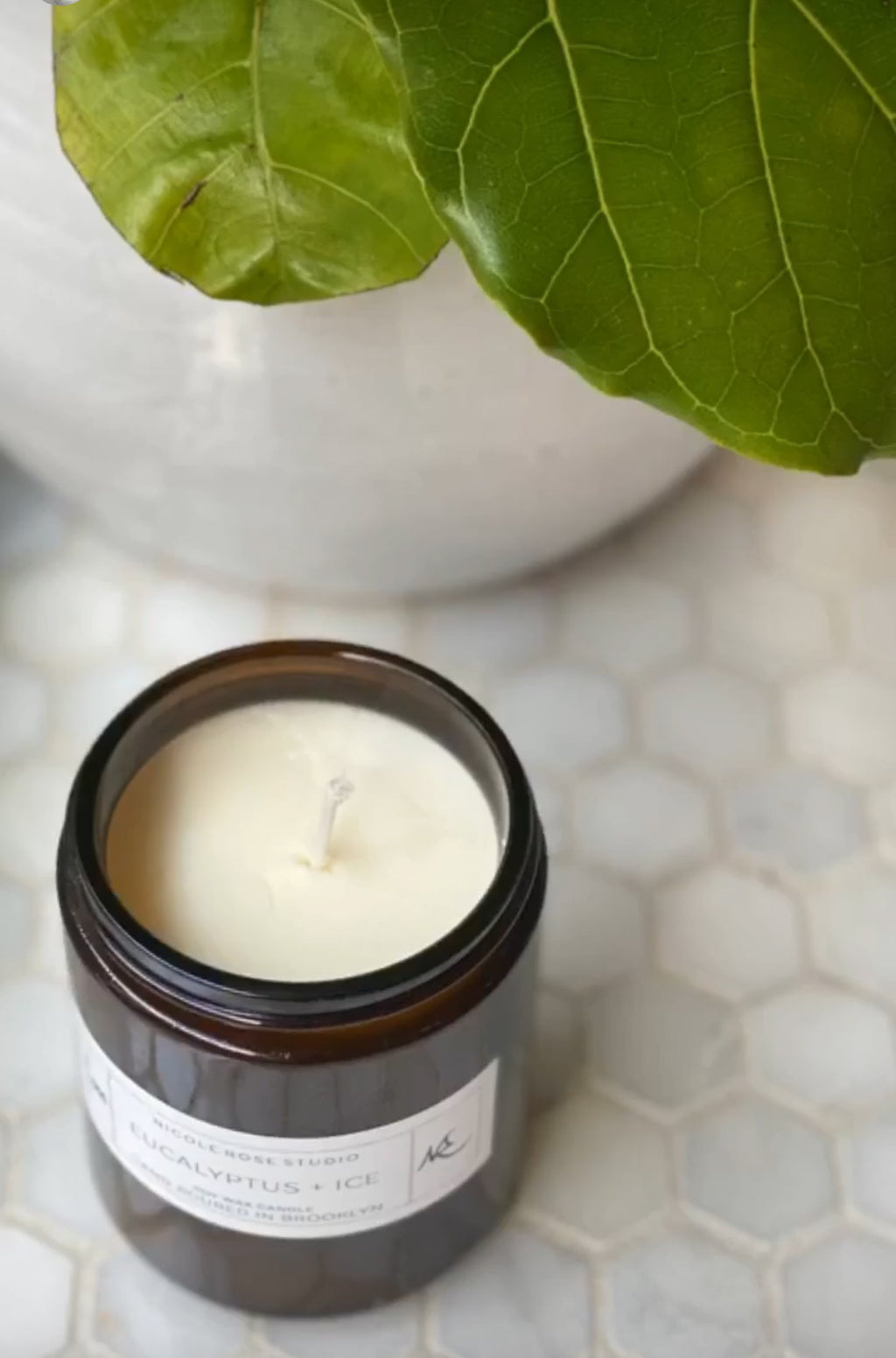 Minimalist soy candle in amber jar with clean white wax for calming ambiance.
