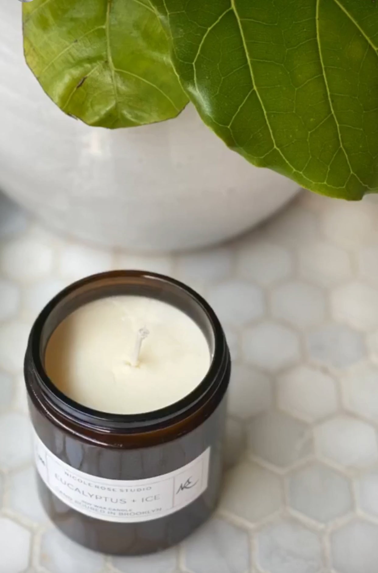 Minimalist soy candle in amber jar with clean white wax for calming ambiance.
