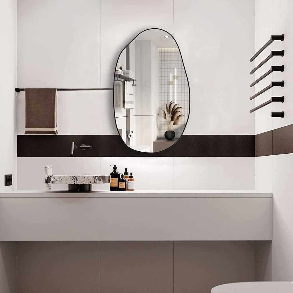 Irregular oval wall mirror with black frame, perfect for modern bathroom vanity decor.
