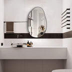 Irregular oval wall mirror with black frame, perfect for modern bathroom vanity decor.
