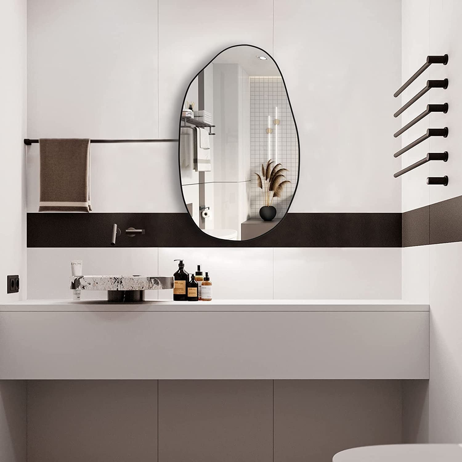 Irregular oval wall mirror with black frame, perfect for modern bathroom vanity decor.
