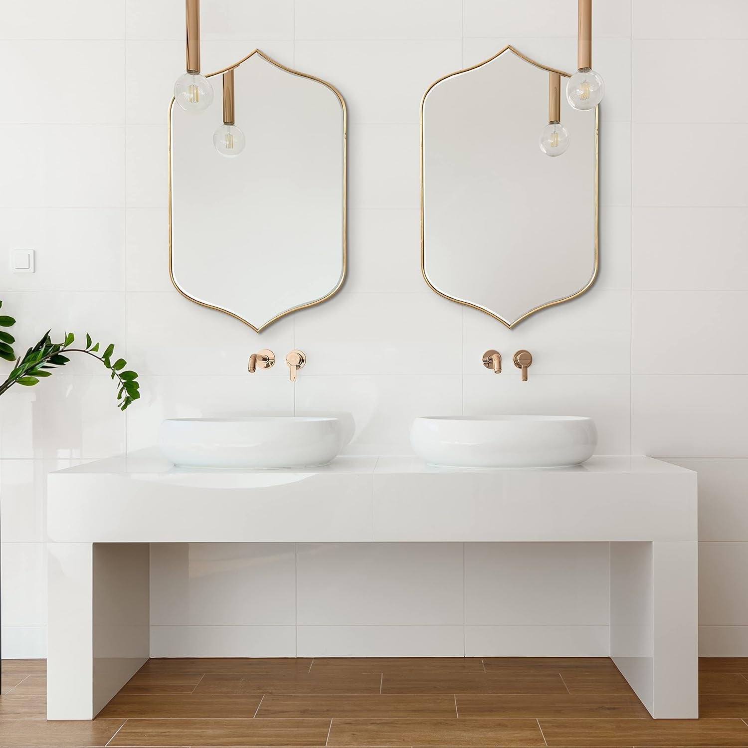 Set of two gold-framed arched wall mirrors, perfect for modern bathroom vanity decor.
