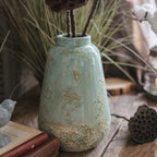 Rustic green ceramic vase with distressed finish for farmhouse and vintage home decor.
