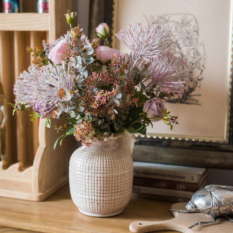 Ceramic vase with pastel flowers and greenery for elegant rustic home decor.
