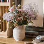 Ceramic vase with pastel flowers and greenery for elegant rustic home decor.
