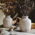 Rustic ceramic vases with dried flowers for vintage farmhouse home decoration.
