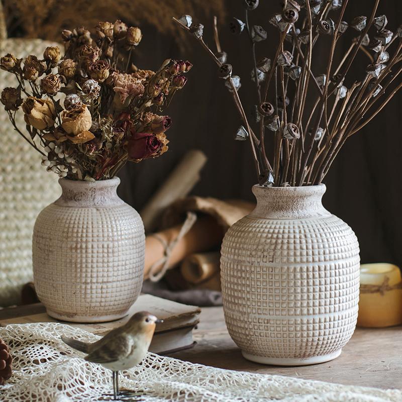 Rustic ceramic vases with dried flowers for vintage farmhouse home decoration.
