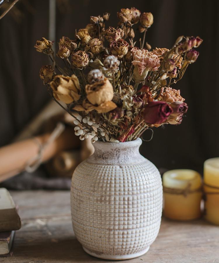 Rustic ceramic vase with dried flowers for vintage home and table decor.