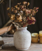 Rustic ceramic vase with dried flowers for vintage home and table decor.
